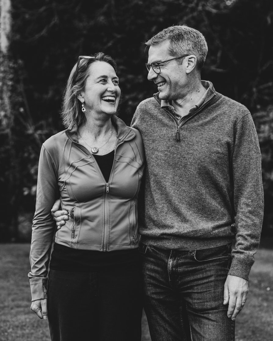 A couple laugh while looking at each other.