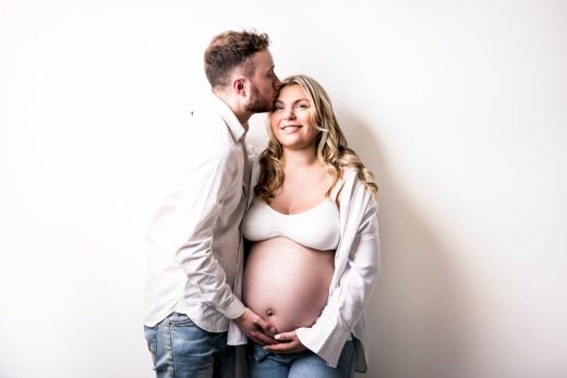 STUDIO COUPLE PHOTOS FOR MATERNITY SESSION ON WHITE BACKGROUND