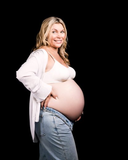 STUDIO COUPLE PHOTOS FOR MATERNITY SESSION ON BLACK BACKGROUND