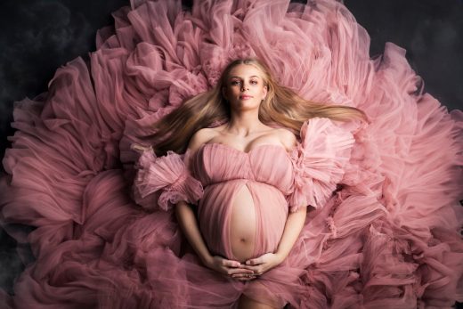Studio photos of a young mum to be in a beautiful pink floaty dress
